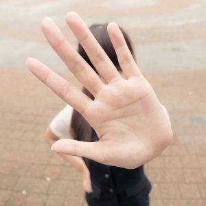 Girl with hand up in "no" gesture