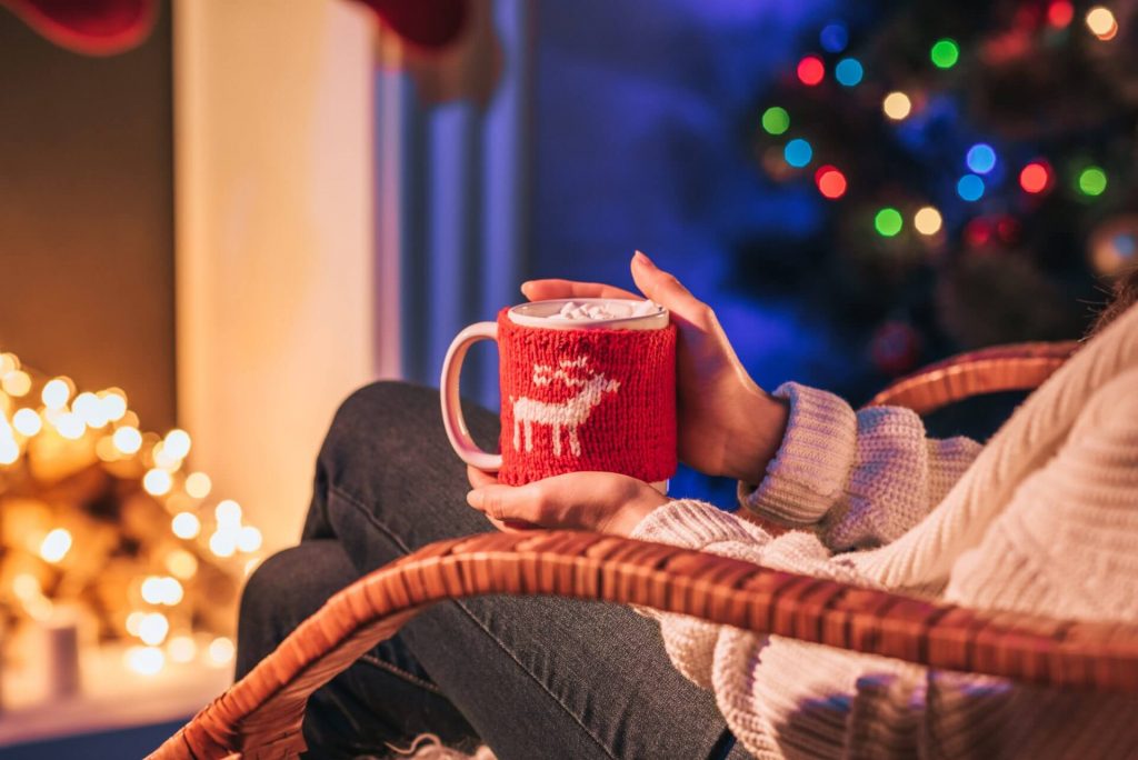 woman in front of fire with hot chocolate