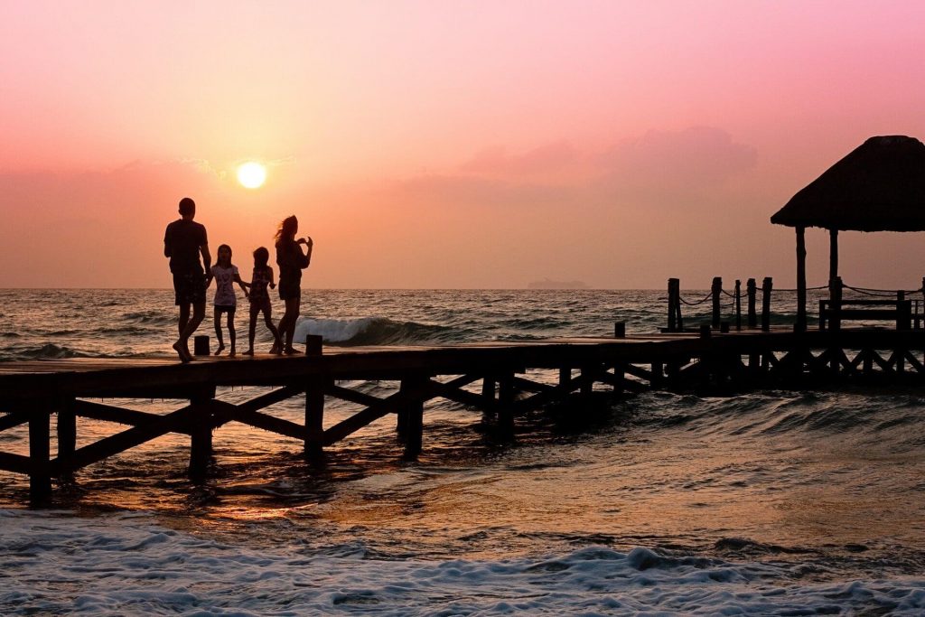 Family with two children walking on pier at beach